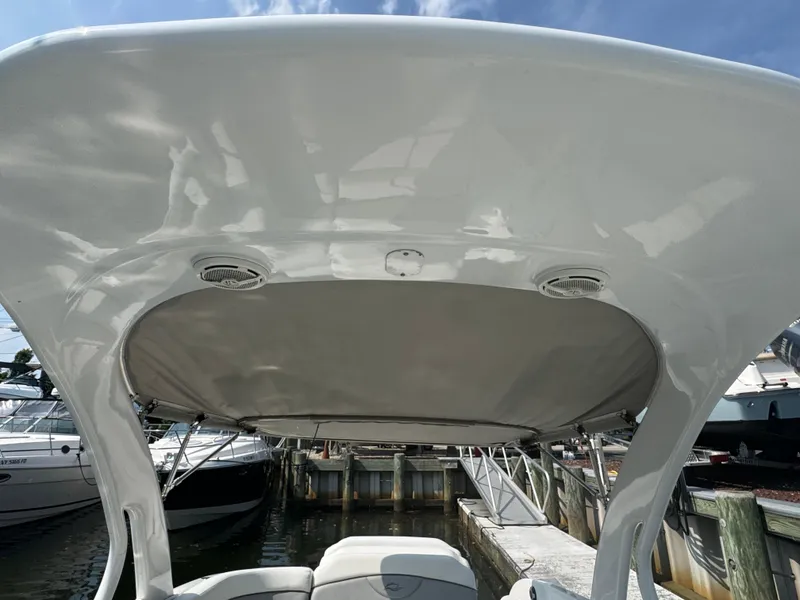 Slide: The Image of 2013 Rinker 296 Captiva Bowrider with canopy, docked at marina under clear sky. - 14
