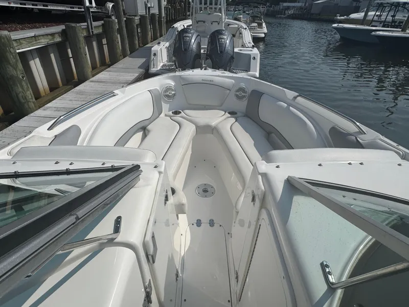 Slide: The Image of 2013 Rinker 296 Captiva Bowrider with spacious seating, docked by the water. - 15