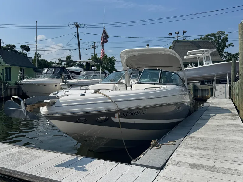 Slide: The Image of 2013 Rinker 296 Captiva Bowrider docked at marina under clear blue sky. - 19