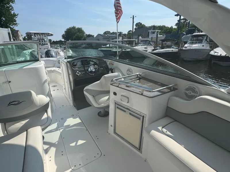 Slide: The Image of 2013 Rinker 296 Captiva Bowrider interior with helm, seating, and American flag. - 6