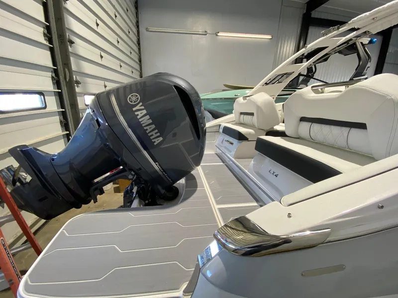 Slide: The Image of 2024 Regal LX4 boat with Yamaha outboard motor in a garage setting. - 3
