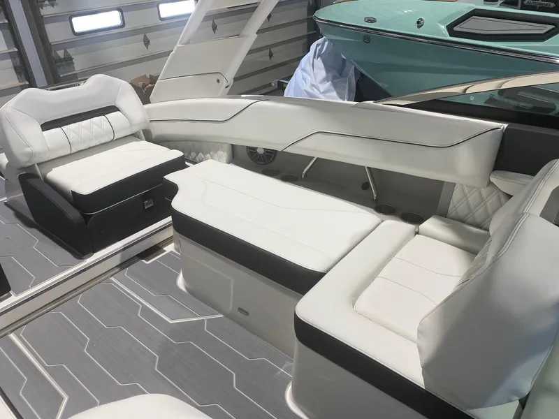 Slide: The Image of 2024 Regal LX4 boat interior with white and black seating in a garage setting. - 7