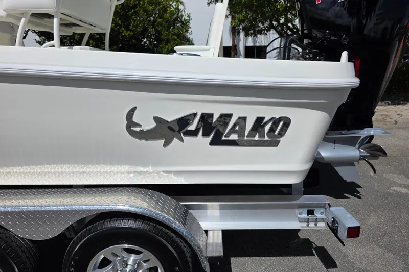 Slide: The Image of 2025 Mako 24 APEX boat on trailer, featuring sleek design and logo. - 16