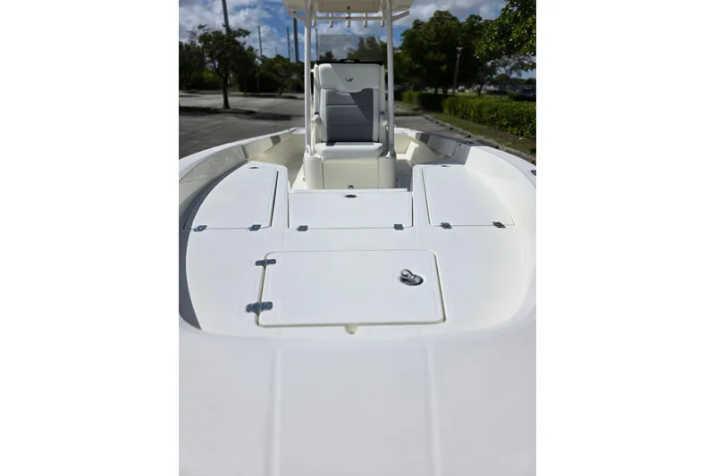 Slide: The Image of 2025 Mako 24 APEX boat deck with storage compartments and seating, outdoors. - 7