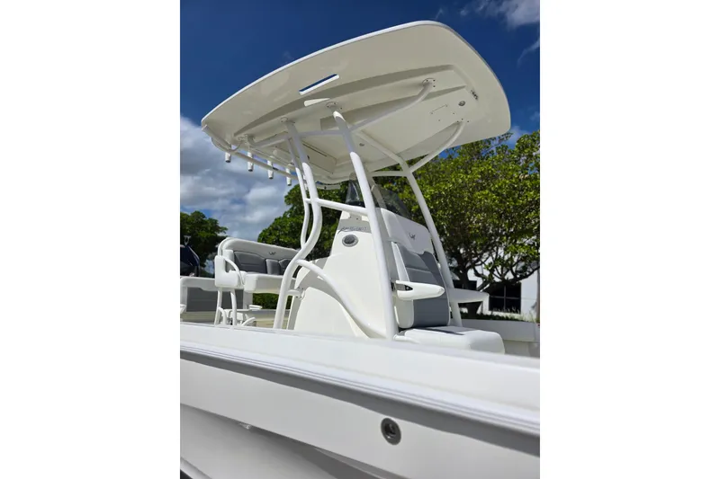 Slide: The Image of 2025 Mako 24 APEX boat with sleek design and modern seating under a clear blue sky. - 8