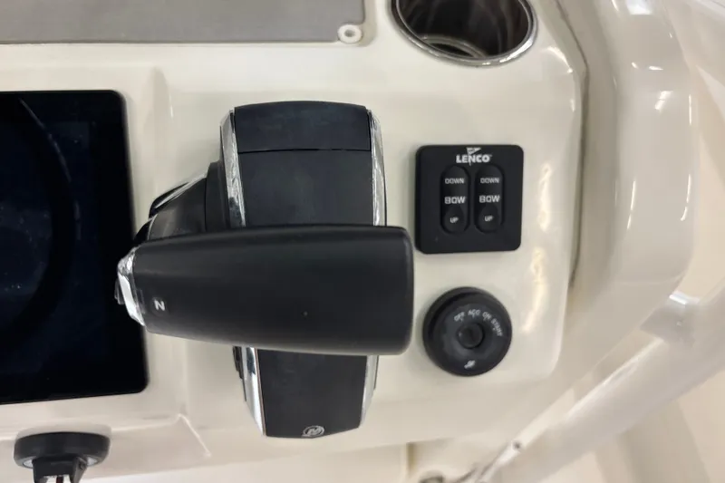 Slide: The Image of Close-up of 2025 Mako 24 APEX boat controls, featuring throttle and Lenco trim tab switches. - 29