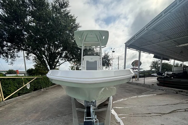 Slide: The Image of 2025 Mako 24 APEX boat displayed outdoors under cloudy sky. - 2