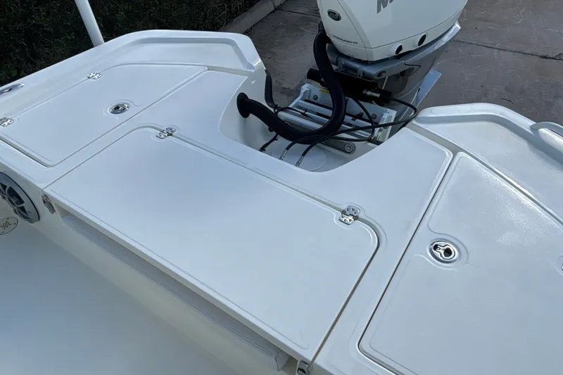 Slide: The Image of 2025 Mako 24 APEX boat deck with motor, featuring storage compartments and sleek design. - 22