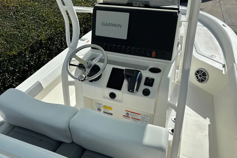 Slide: The Image of 2025 Mako 24 APEX boat console with Garmin display and steering wheel. - 24