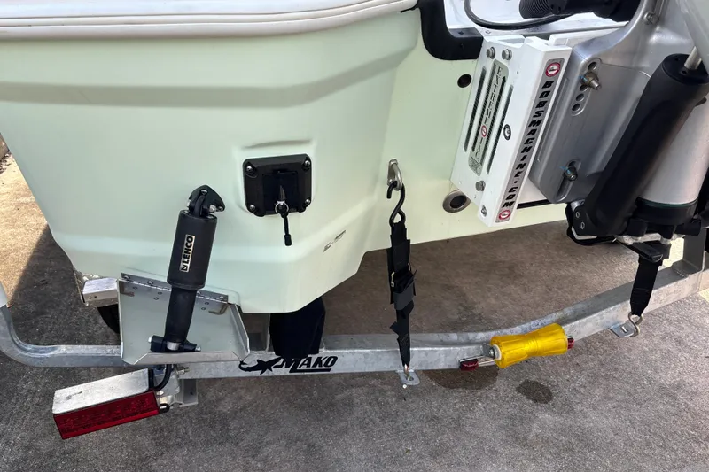 Slide: The Image of Rear view of a 2025 Mako 24 APEX boat on a trailer, showcasing trim tabs and motor mount. - 32