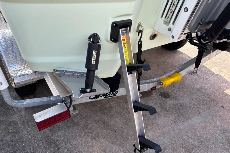 Slide: The Image of Rear view of 2025 Mako 24 APEX boat with ladder and trailer. - 33