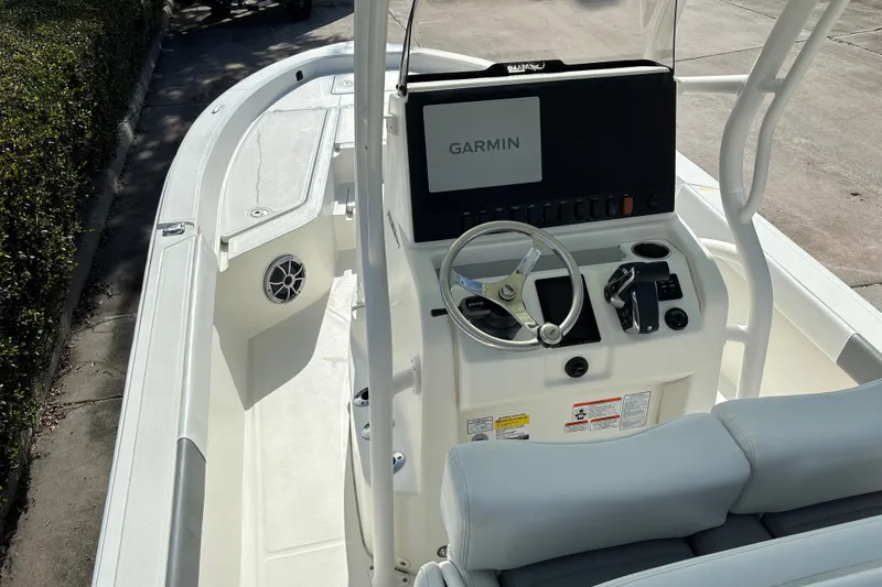 Slide: The Image of 2025 Mako 24 APEX boat interior with Garmin navigation system and steering wheel. - 25
