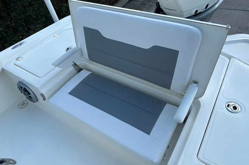 Slide: The Image of 2025 Mako 24 APEX boat seat with gray and white upholstery, featuring storage compartment. - 21