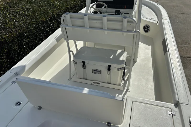 Slide: The Image of 2025 Mako 24 APEX boat interior with seating and storage cooler. - 13