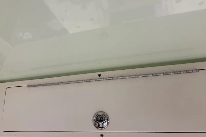 Slide: The Image of Mako 24 APEX 2025 boat hatch with a secure lock and measuring scale. - 37
