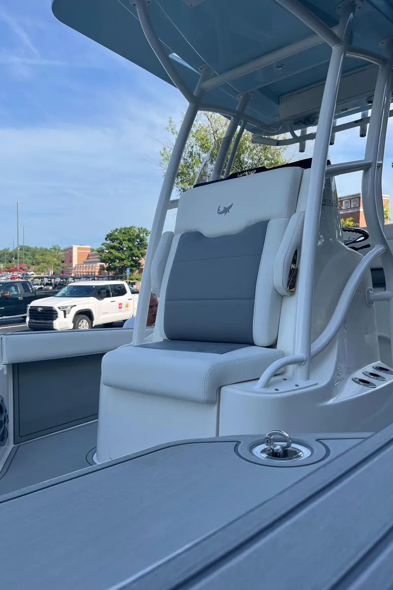 Slide: The Image of 2025 Mako 24 APEX boat interior with cushioned seating and sleek design. - 5