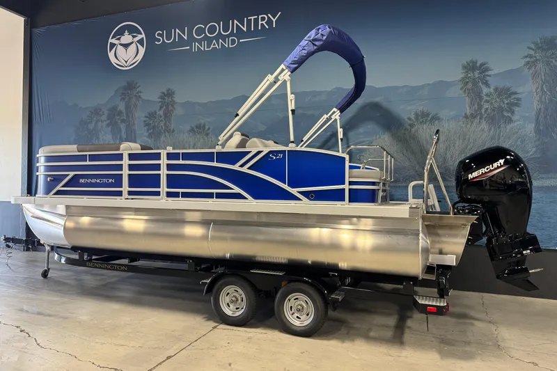 Slide: The Image of 2026 Bennington 21 SSB pontoon boat with Mercury engine on display indoors. - 4