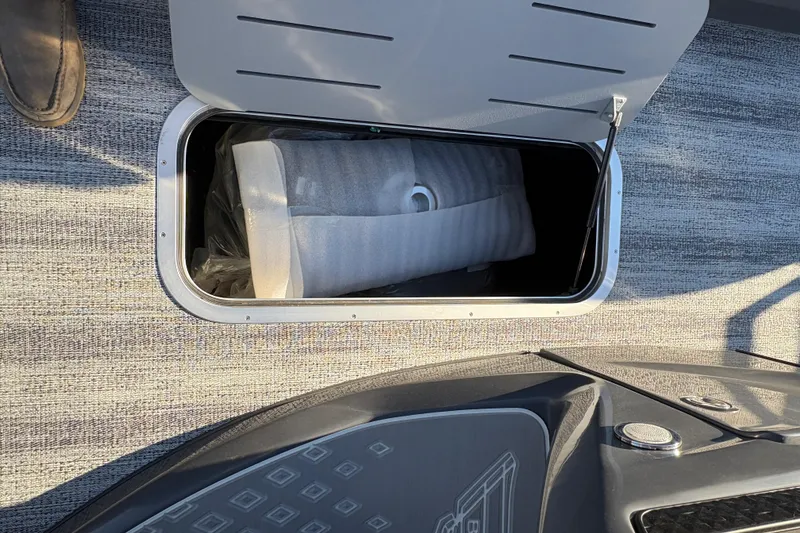 Slide: The Image of Open storage compartment on 2026 Bennington 22 MFB boat, revealing interior contents. - 14