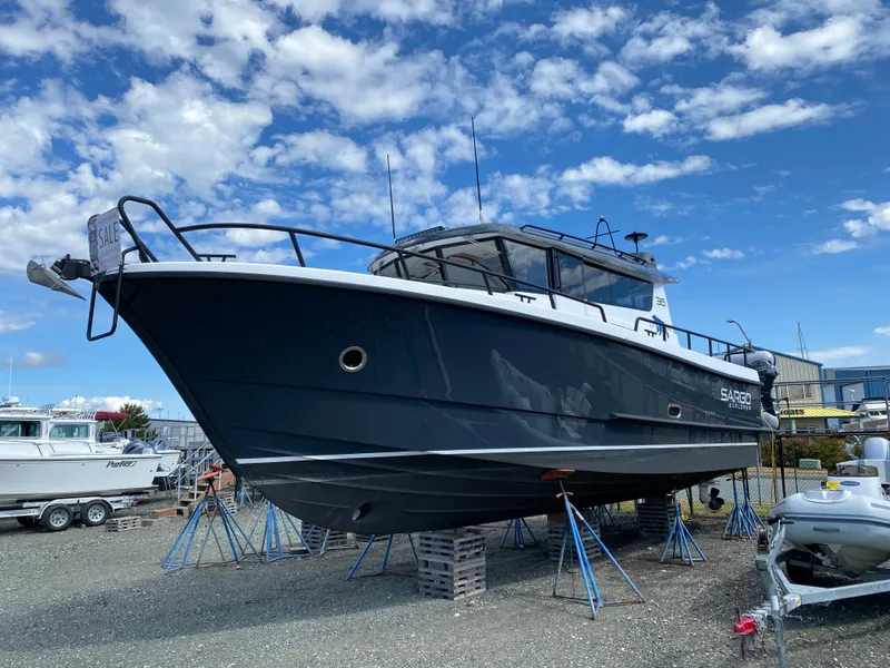 The Image of 2019 Sargo 36 Explorer boat on stands, under a partly cloudy sky. - 0