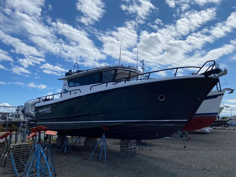 Slide: The Image of 2019 Sargo 36 Explorer boat on stands under a partly cloudy sky. - 1