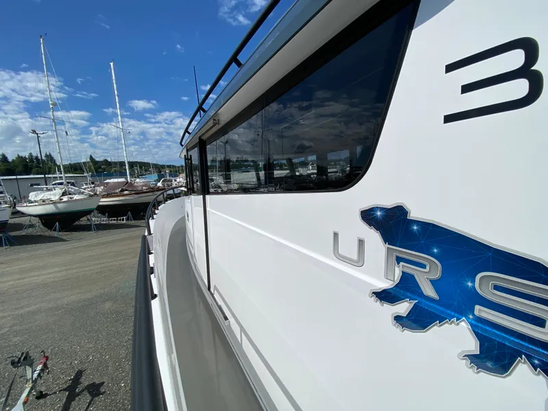 Slide: The Image of 2019 Sargo 36 Explorer boat side view with logo, docked near sailboats under blue sky. - 10