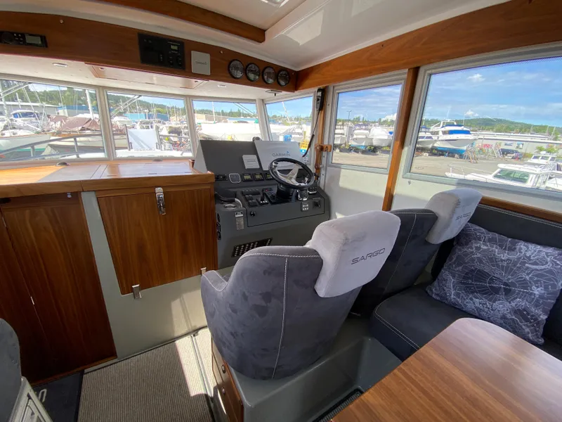 Slide: The Image of Interior of 2019 Sargo 36 Explorer boat with helm, wooden cabinetry, and marina view. - 13