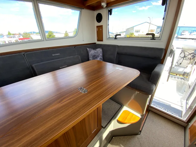 Slide: The Image of Interior of 2019 Sargo 36 Explorer with wooden table and cushioned seating. - 27