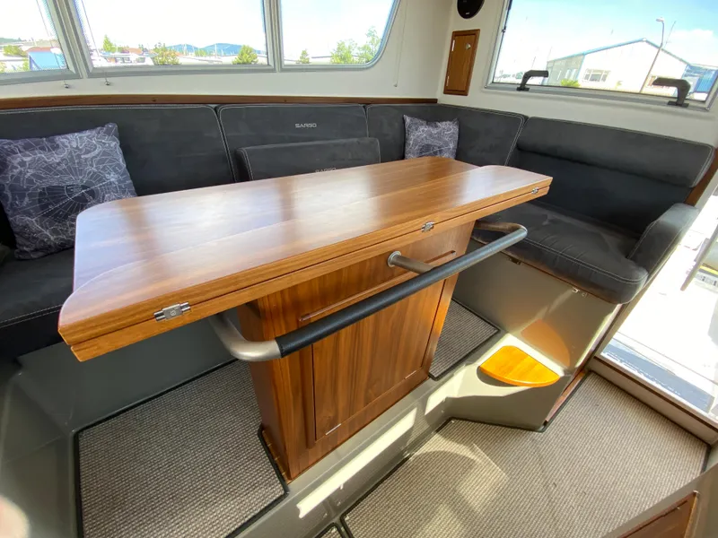 Slide: The Image of Interior of 2019 Sargo 36 Explorer with wooden table and cushioned seating. - 28