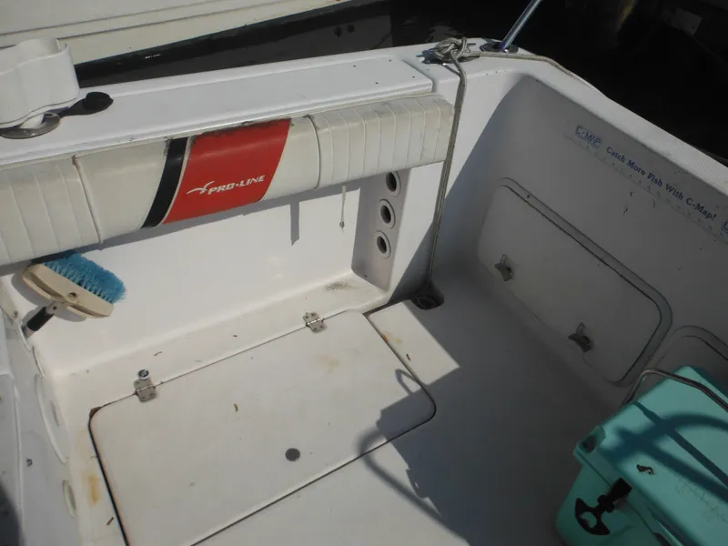 Slide: The Image of 2002 Pro-Line 23 Walk boat interior with storage compartments and cleaning brush. - 18