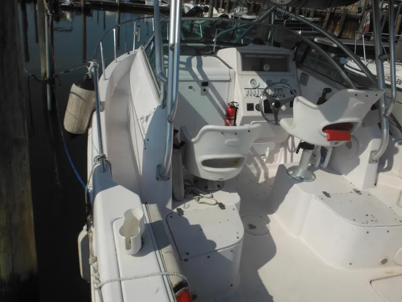 Slide: The Image of 2002 Pro-Line 23 Walk boat interior with helm, seats, and controls at dock. - 5