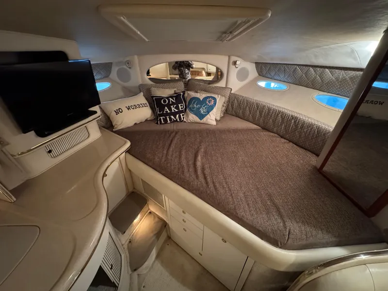 Slide: The Image of Cozy cabin interior of 2001 Sea Ray 310 Sundancer with plush bedding and decorative pillows. - 11