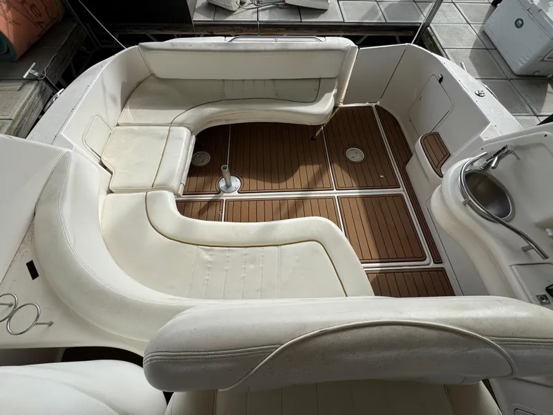 Slide: The Image of 2001 Sea Ray 310 Sundancer boat interior with white seating and wood flooring. - 14