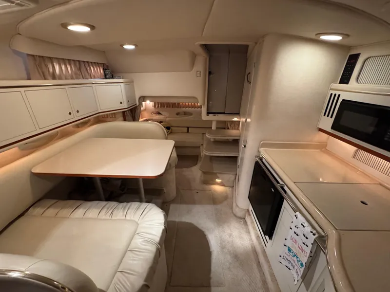 Slide: The Image of Interior of 2001 Sea Ray 310 Sundancer yacht with kitchenette and seating area. - 4