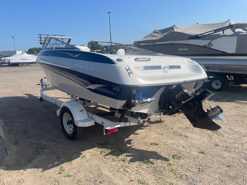 Slide: The Image of 2002 Crownline 180 BR boat on trailer, parked outdoors under clear sky. - 15