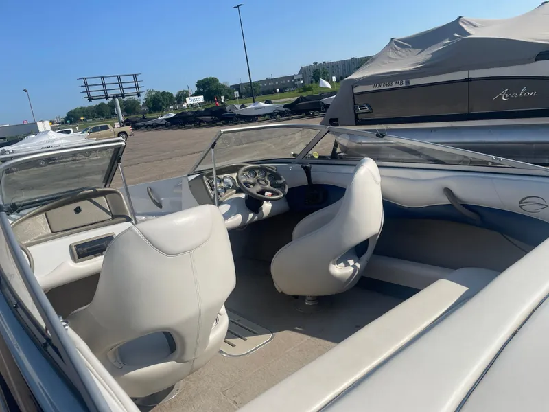 Slide: The Image of Interior of a 2002 Crownline 180 BR boat with white seating and dashboard. - 16