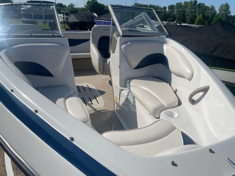 Slide: The Image of 2002 Crownline 180 BR boat interior with white seating and open windshield. - 19