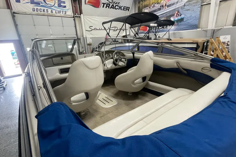 Slide: The Image of 2002 Crownline 180 BR boat interior with white seats and blue accents in showroom. - 5