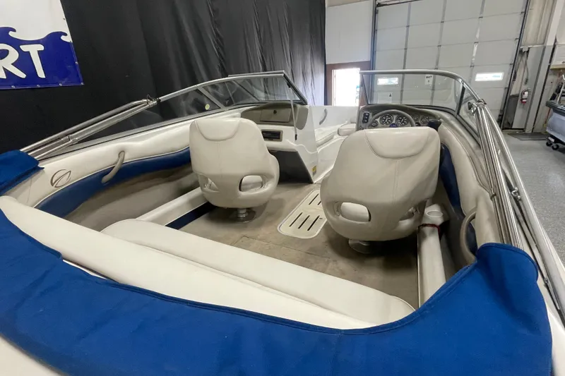 Slide: The Image of 2002 Crownline 180 BR boat interior with white seats and blue accents. - 6
