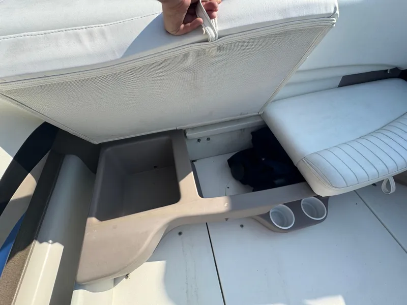 Slide: The Image of 2003 Glastron SX 195 boat interior with open storage compartment and cup holders. - 14
