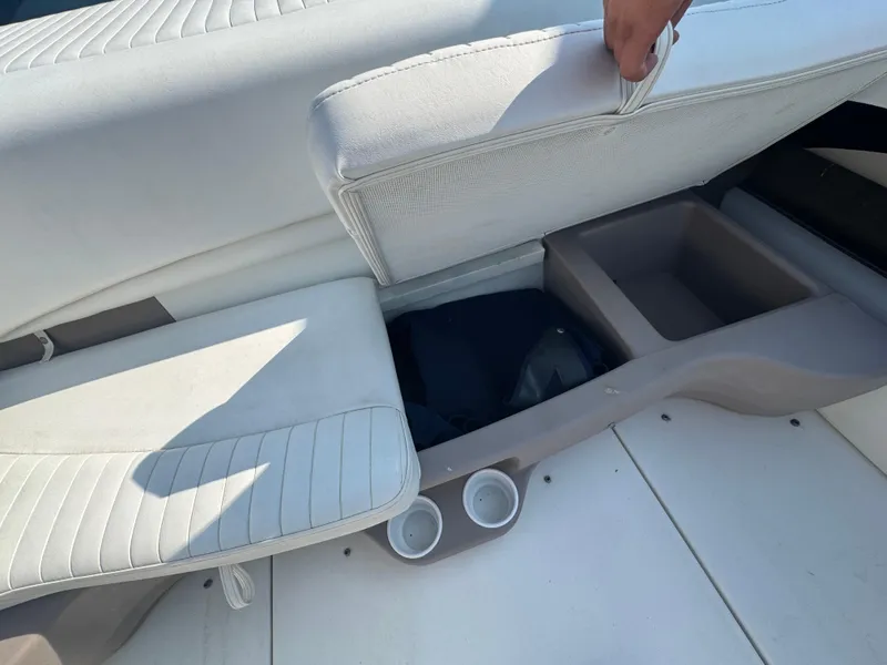 Slide: The Image of 2003 Glastron SX 195 boat interior with open storage compartment and cup holders. - 15
