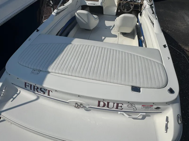 Slide: The Image of 2003 Glastron SX 195 boat interior with white seating and "First Due" text on the back. - 4