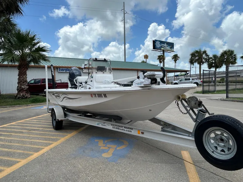 Slide: The Image of 2012 Blue Wave 1900 STL boat on trailer in parking lot, palm trees in background. - 4