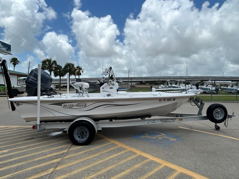 Slide: The Image of 2012 Blue Wave 1900 STL boat on trailer, parked outdoors under cloudy sky. - 5