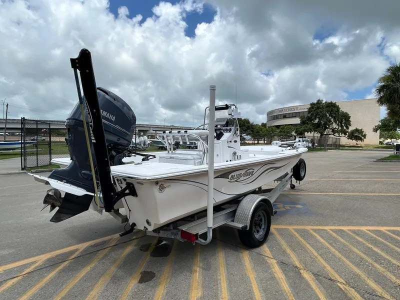 Slide: The Image of 2012 Blue Wave 1900 STL boat on trailer, parked outdoors under cloudy sky. - 6