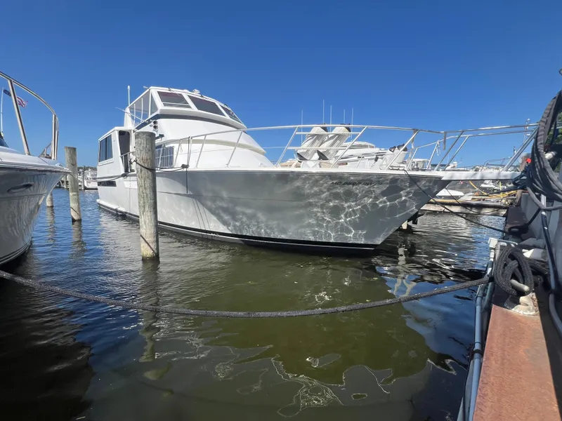 The Image of 1995 Viking Sports Yacht docked at marina under clear blue sky. - 0