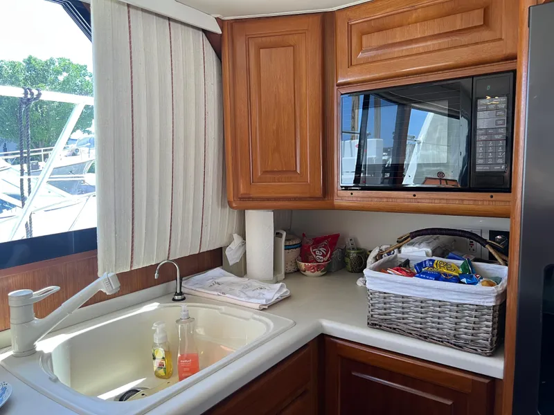Slide: The Image of Interior of 1995 Viking Sports Yacht kitchen with sink, microwave, and snack basket. - 21