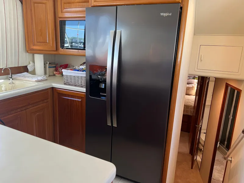 Slide: The Image of Kitchen area of a 1995 Viking Sports Yacht with modern appliances and wooden cabinetry. - 22