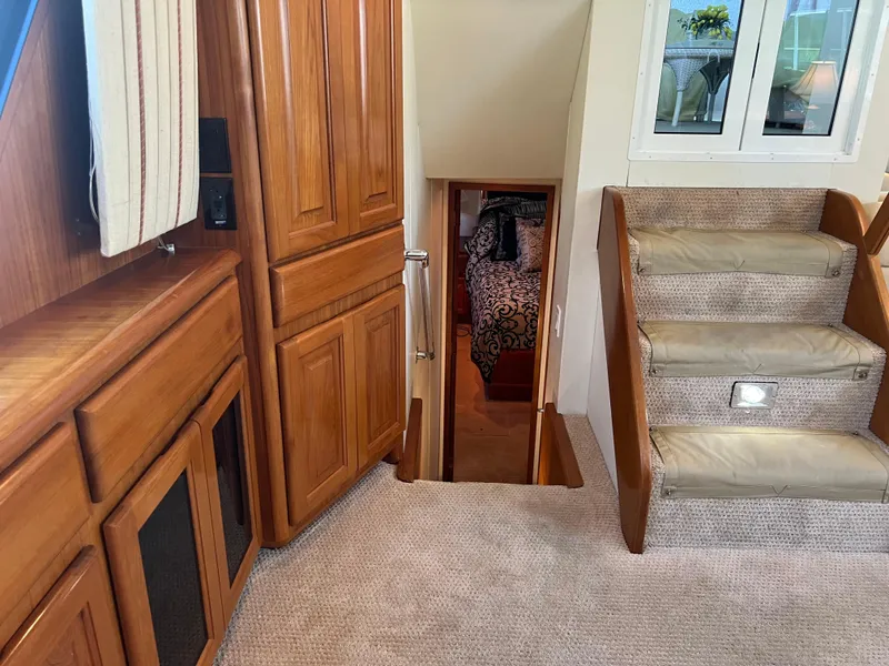 Slide: The Image of Interior of 1995 Viking Sports Yacht with wooden cabinetry and carpeted stairs. - 28