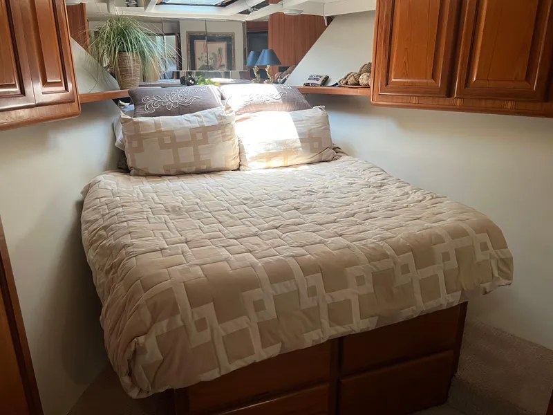 Slide: The Image of Cozy bedroom interior of 1995 Viking Sports Yacht with wooden cabinets and patterned bedding. - 38