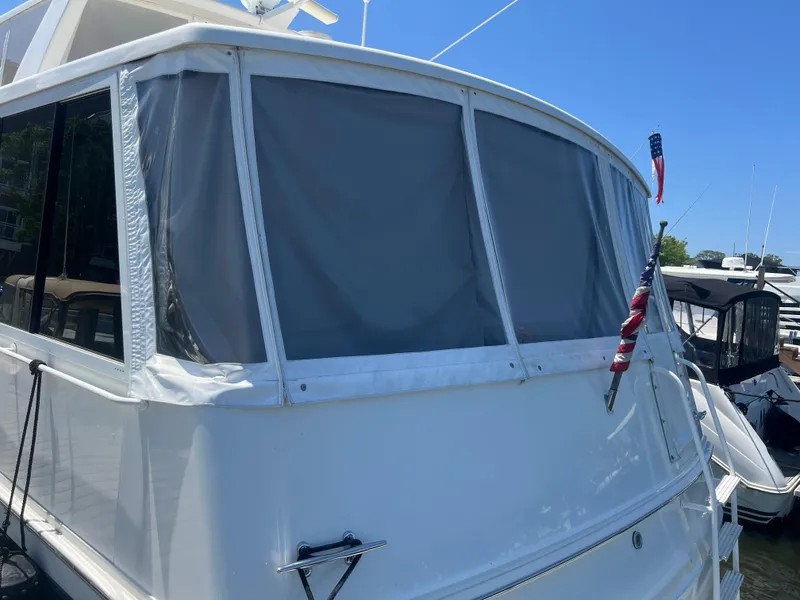 Slide: The Image of 1995 Viking Sports Yacht with American flag, docked under clear blue sky. - 4